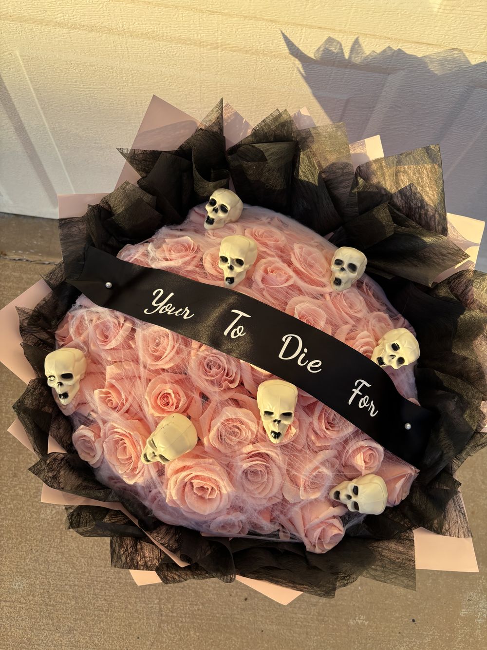 Pink ribbon rose bouquet with skulls and a Yours To Die For ribbon